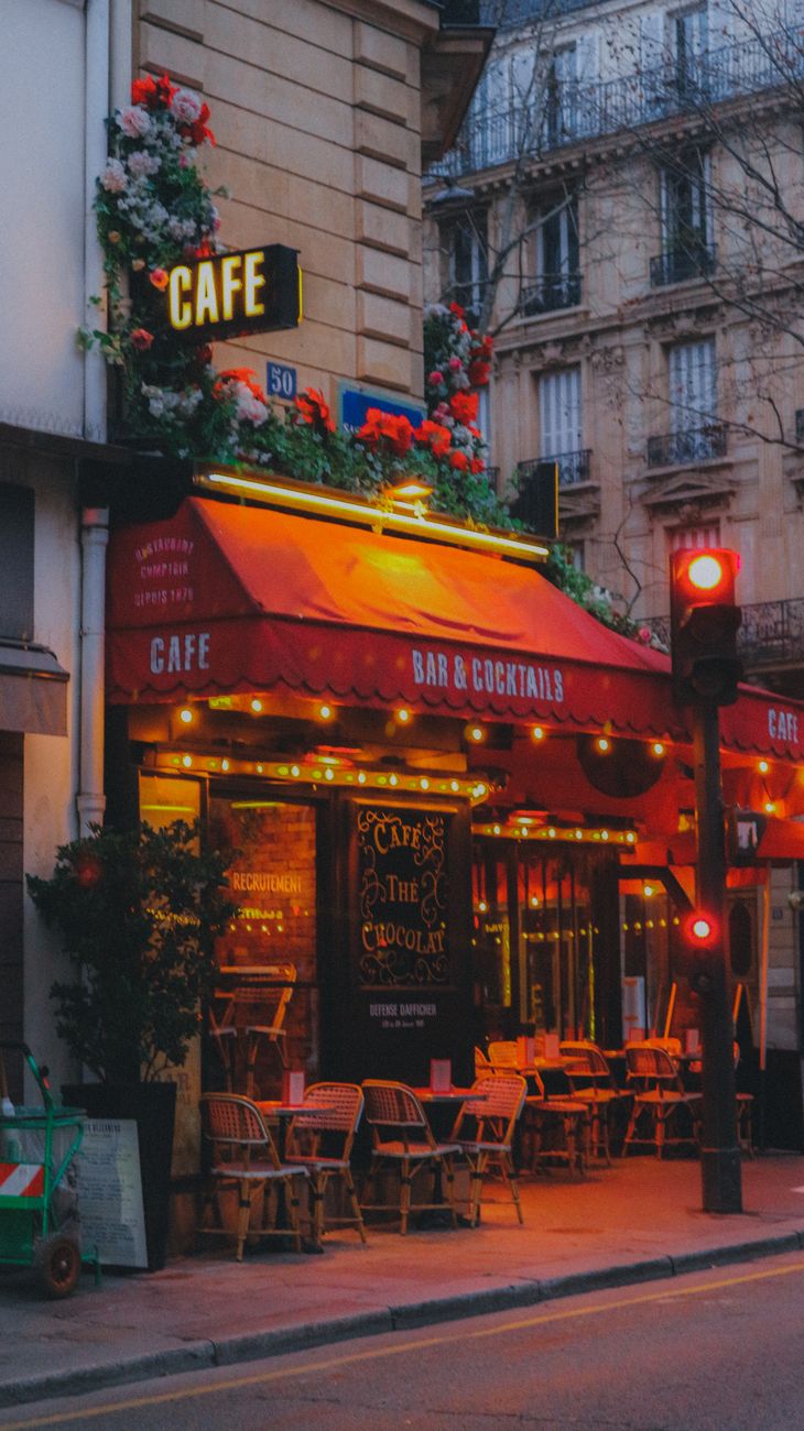 illuminated exterior of a cafe and bar in the evening in city